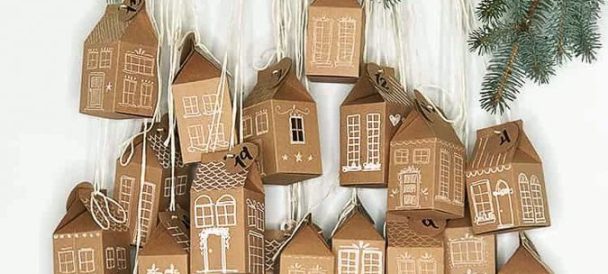 Obrazek przedstawia tekturowe domki. tworzące kalendarz adwentowy.